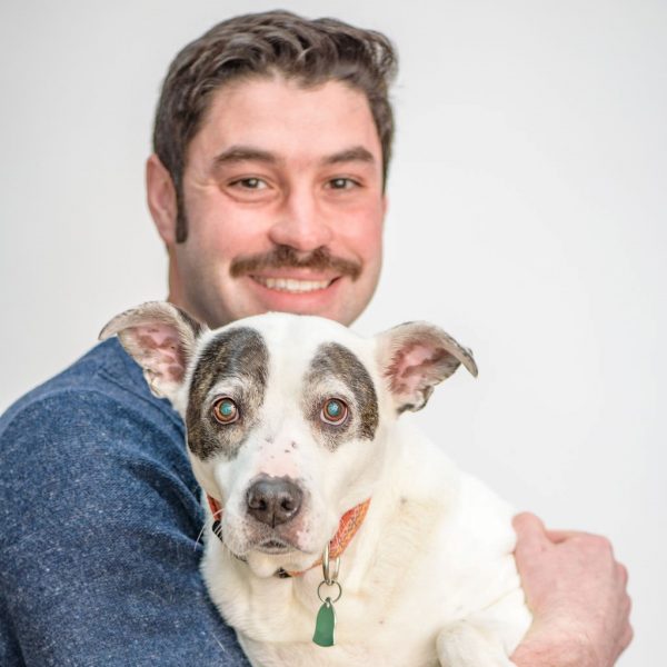 Searle smiling and holding dog