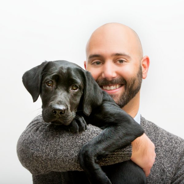 Man holding black lab puppy
