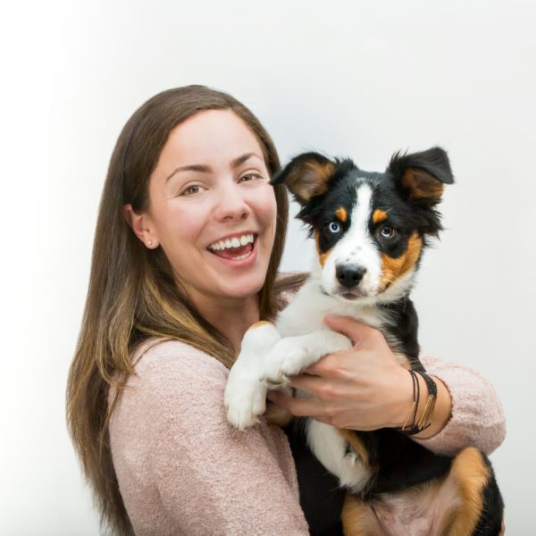 Woman posing for a photo with a puppy