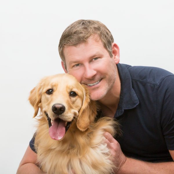 Man posing for photo with golden retriever
