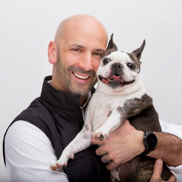 Man smiling holding a Boston terrier