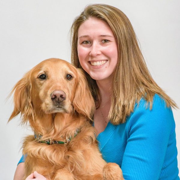 Woman smiling posing for photo with Golden Retriever