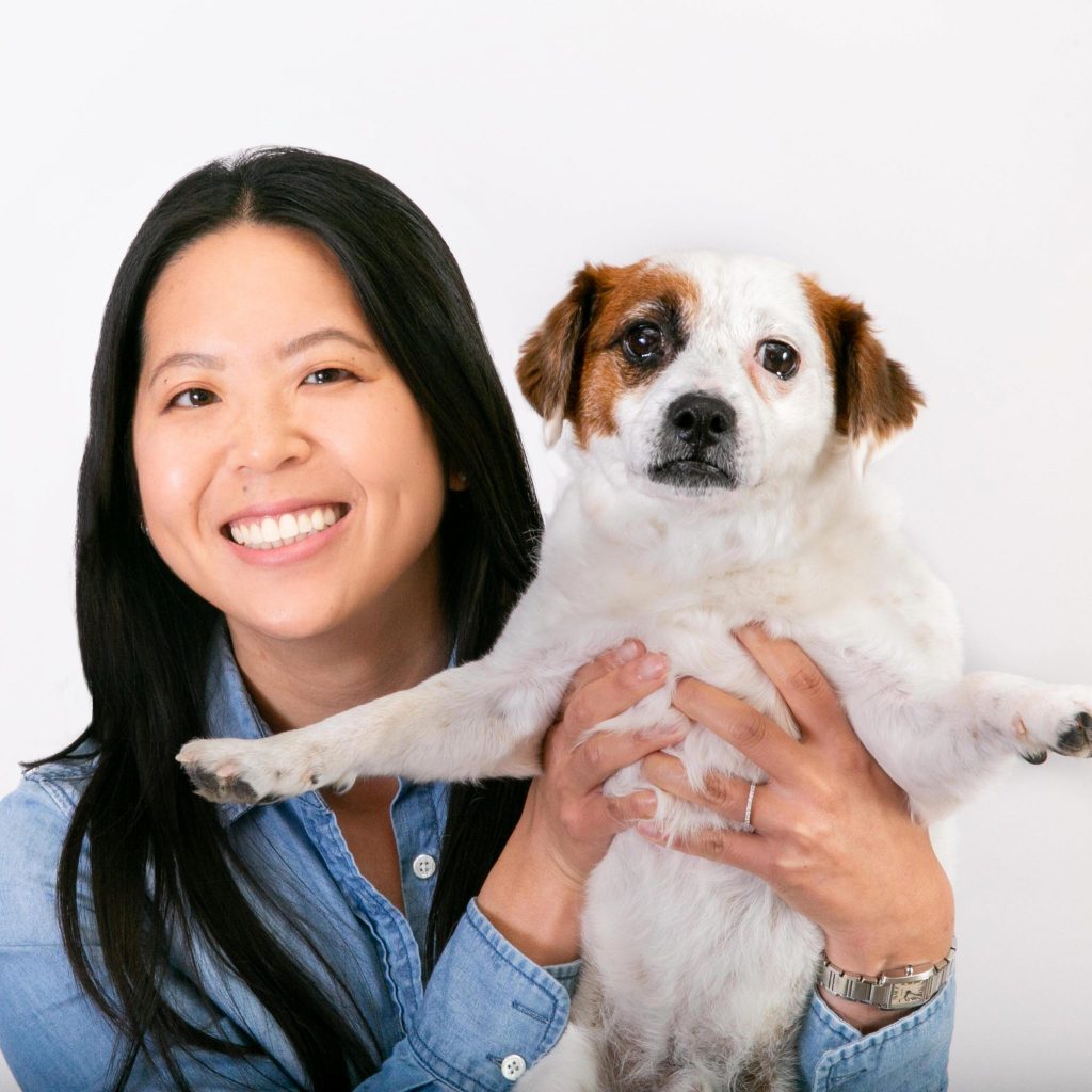 Elaine Yip smiling and holding a dog
