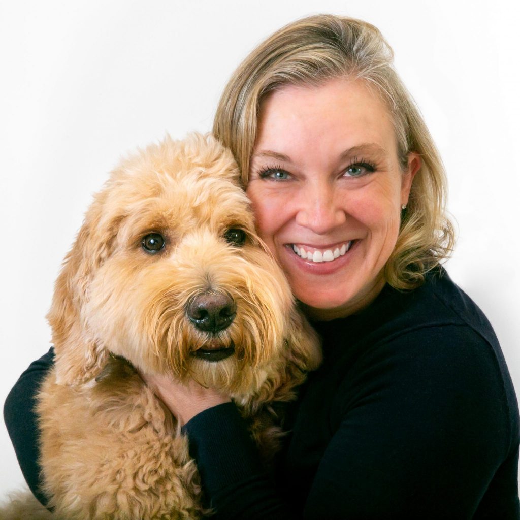 Sarah Mills smiling with a dog