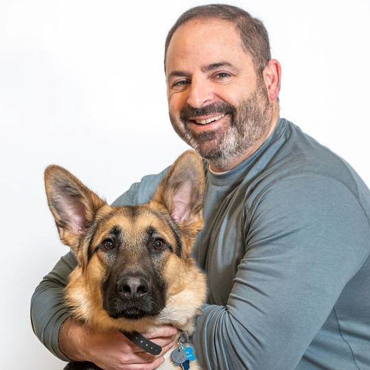 Jim Baron smiling with a dog
