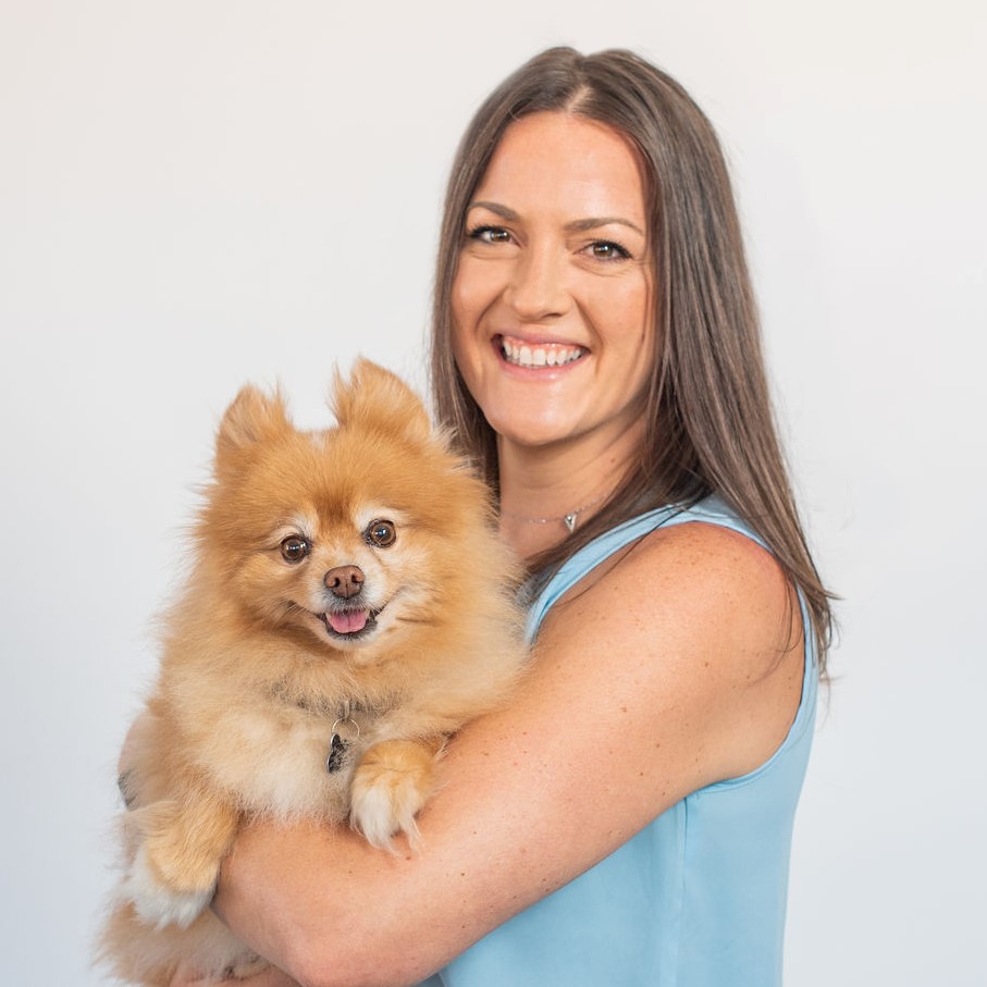 Christie Verschoor smiling and holding a small dog