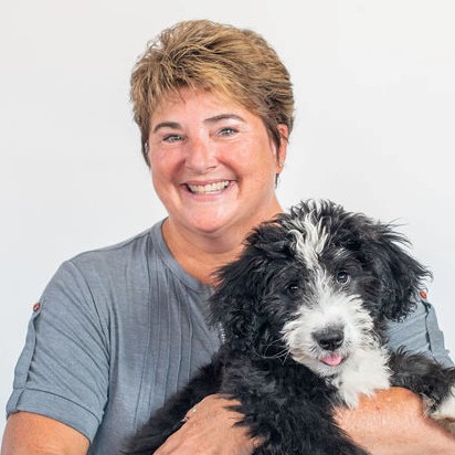Rhonda Kromer smiling and holding a puppy